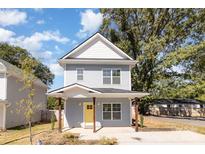 Two-story gray house with yellow door and porch at 1034 Gaston Ave, Gastonia, NC 28052