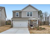 Two-story house with gray siding, white garage door, and landscaping at 4445 Dusty Orchard Rd, Kannapolis, NC 28081