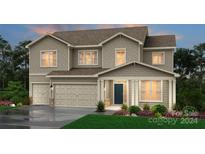 Two-story home with beige siding, two-car garage, and landscaping at 220 E Warfield Dr, Mooresville, NC 28115