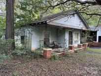 Small cottage with a front porch and overgrown yard at 213 Belt Dr, Lowell, NC 28056