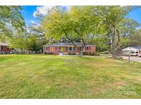 Brick ranch house with a spacious yard and mature trees at 102 Harmony Trl, Gastonia, NC 28056