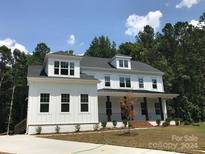 Stunning two-story farmhouse with white siding, a covered porch, and manicured lawn at 0001 Bolton Rd, Catawba, NC 28609