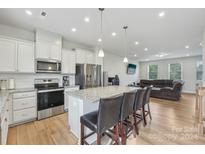 Modern kitchen with island, stainless steel appliances, and hardwood floors at 1134 Keydet Dr, Charlotte, NC 28216