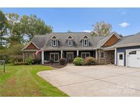 Two-story home with stone and blue siding, and a large driveway at 2202 Graham Rd, Mt Ulla, NC 28125