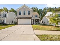 Two-story house with a neutral exterior, stone accents, and a front porch at 3020 Pinehills Way, Mount Holly, NC 28120