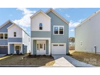 Two-story light blue house with a white garage door and nicely landscaped lawn at 432 Kingsway Cir, Charlotte, NC 28214