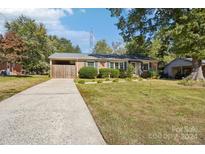 Brick ranch home with a driveway and fenced yard at 1026 Holly Dr, Gastonia, NC 28054