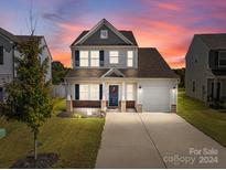 Two-story home with a gray roof and brick facade, featuring a welcoming front porch at 1109 Freeman View Dr, Albemarle, NC 28001