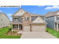 Two-story home with stone and siding accents, two-car garage, and landscaping at 147 Saidin Ln, Troutman, NC 28166