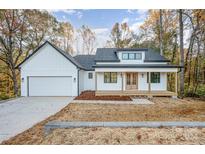 White farmhouse exterior with black roof, front porch, and attached garage at 1043 Lester Rd, Clover, SC 29710