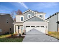 Two-story home with gray and beige siding, two-car garage, and landscaping at 323 Bezelle Ave, York, SC 29745