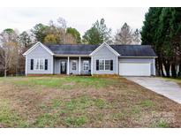 Gray vinyl-sided house with a white garage door and landscaping at 418 Summer Ridge Rd, Stanley, NC 28164