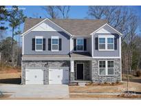 Two-story home with gray siding, stone accents, and a two-car garage at 47 Sherwood Nw Ct # Sw47, Concord, NC 28027