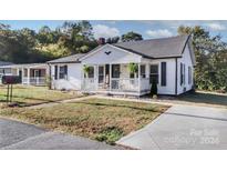 White house with front porch and yard at 1002 Aiken St, Kannapolis, NC 28081