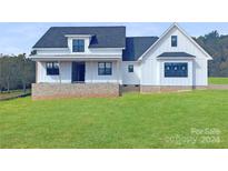 Modern farmhouse exterior with white siding, brick base, and green lawn at 615 Sandycrest Dr, Cherryville, NC 28021