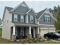 Two-story house with gray siding, stone accents, and a two-car garage at 177 Rhuidean Ct, Troutman, NC 28166