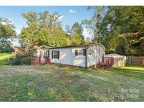 Single-wide mobile home with wooden deck and surrounding yard at 1472 Fritts Ave, Fort Mill, SC 29715