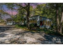 Ranch style home with a red door, nestled amongst lush trees at 1141 Bate Harvey Rd, Clover, SC 29710