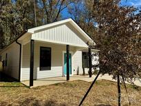 Newly constructed home with gray siding, a teal door, and a covered porch at 1712 Mcdonald St, Charlotte, NC 28216