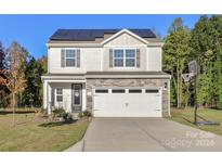 Two-story house with a two-car garage and solar panels at 140 Tanner Loop, Troutman, NC 28166
