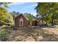 Brick home with landscaped yard and mature trees at 4823 Morris Glen Dr, Concord, NC 28027