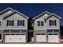 Two-unit townhome building with gray siding, stone accents, and attached garages at 4057 Port Richmond Ave # 13, Gastonia, NC 28056