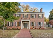 Brick two-story home with a classic design, landscaped yard, and walkway at 405 S Church St, Monroe, NC 28112