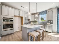 Modern kitchen with island, stainless steel appliances, and window at 1406 Hubert Graham Way, Tega Cay, SC 29708