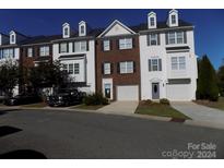 Three-story townhome with a two-car garage and well-maintained landscaping at 141 Rock Ridge Ln, Mount Holly, NC 28120