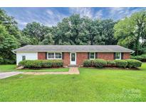Brick ranch house with a well-maintained lawn and landscaping at 1613 Ohenry Ln, Fort Mill, SC 29708