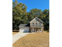 Two-story brick home with a covered porch and attached garage at 1018 Cross Creek Dr, Oakboro, NC 28129