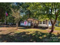 Ranch home with a well-maintained lawn and mature trees at 4108 Scarlet St, Matthews, NC 28104