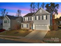 Two story tan house with a two car garage and front yard at 2680 Andes Dr, Statesville, NC 28625
