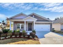 Brick ranch home with 2-car garage and landscaped front yard at 7403 American Elm Rd, Charlotte, NC 28215