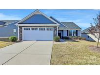 Two-story house with gray siding, stone accents, and a two-car garage at 4321 Stream Dale Nw Cir # 218, Concord, NC 28027