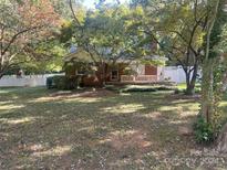 Brick ranch house with a front porch and landscaped yard at 3238 Campbell Dr, Charlotte, NC 28205