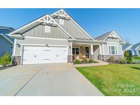 Gray Craftsman style home with a two-car garage and rocking chairs on the porch at 7002 Kingfisher Way, Belmont, NC 28012