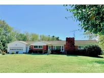 Ranch home with brick facade, attached garage, and spacious lawn at 111 Little River Church Rd, Taylorsville, NC 28681