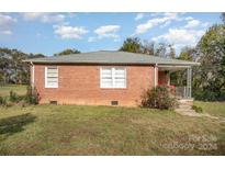 Brick ranch home with a covered porch and large yard at 131 E Branch Ave, Shelby, NC 28152