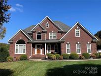 Brick house with a two-car garage, a welcoming porch, and manicured lawn at 103 Berea Baptist Church Rd, Stanfield, NC 28163