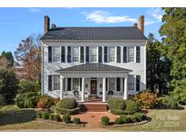 Two-story historic home with a charming front porch and manicured landscaping at 104 Leslie Loop, Mooresville, NC 28115