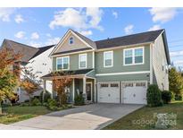 Two-story house with green exterior, two-car garage, and landscaping at 1568 Whitman Ct, York, SC 29745