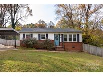 Brick ranch home with carport, landscaping, and fenced yard at 503 Cherry St, Belmont, NC 28012
