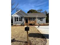 Newly constructed gray house with a front porch and landscaped yard at 1327 Old Salisbury Rd, Statesville, NC 28625