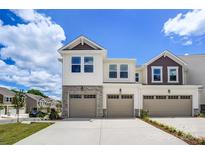 Two-story townhome with two-car garage and stone accents at 14917 Tamarack Dr, Charlotte, NC 28278