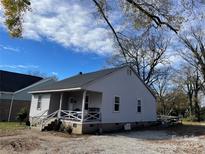 Charming single story home with gray siding, covered porch, and gravel driveway at 922 N Main St, Salisbury, NC 28144