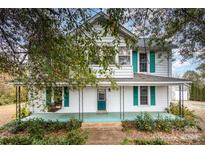 Charming two-story home with teal shutters and a wraparound porch at 1407 N College Ave, Newton, NC 28658