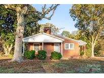 Brick ranch home with covered porch and mature landscaping at 24947 Nc 24/27 Hwy, Albemarle, NC 28001