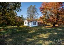 Side view of a white house with covered porch and large yard at 449 Grassy Knob Rd, Union Grove, NC 28689