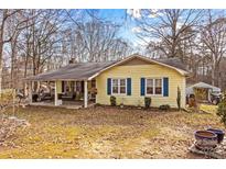 Charming yellow home with blue shutters and covered front porch at 2929 Matoka Trl, Matthews, NC 28104